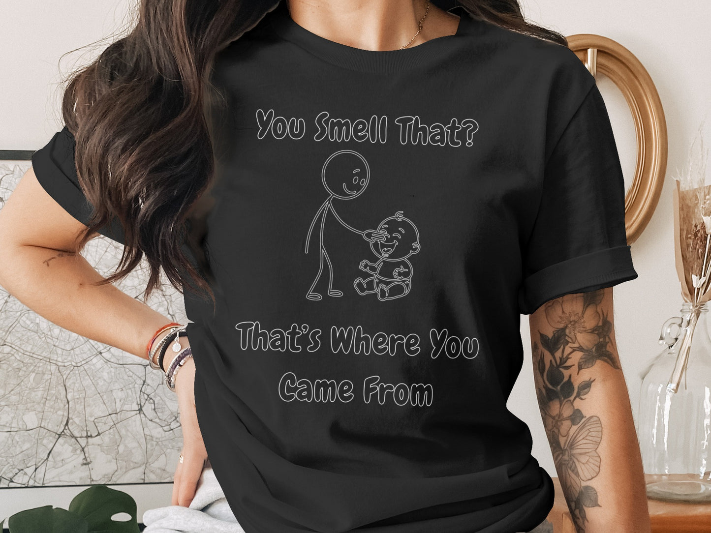 Black t-shirt with white line drawing of parent and baby and text "You Smell That? That's Where You Came From".