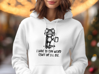 White hoodie with a cartoon frog holding a mug and text that says "I HAVE TO SAY WEIRD STUFF OR I'LL DIE."