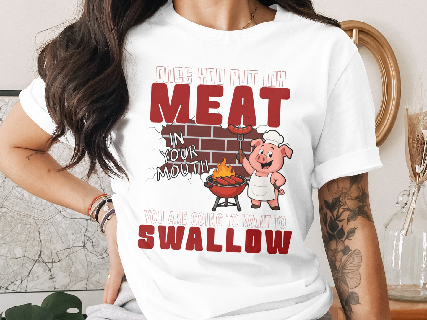 White t-shirt with a cartoon pig grilling and text about meat.