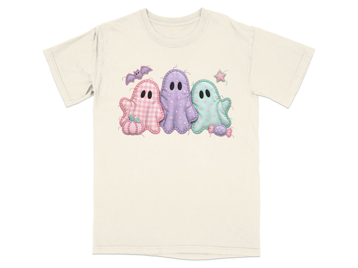 Three pastel patchwork ghosts with Halloween motifs on a cream t-shirt.