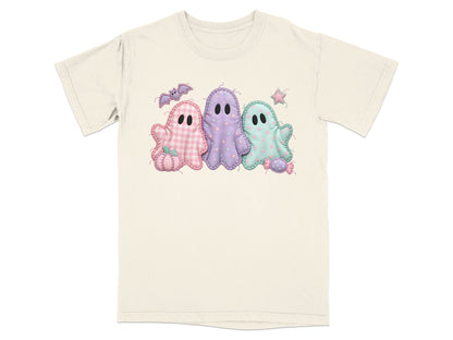 Three pastel patchwork ghosts with Halloween motifs on a cream t-shirt.
