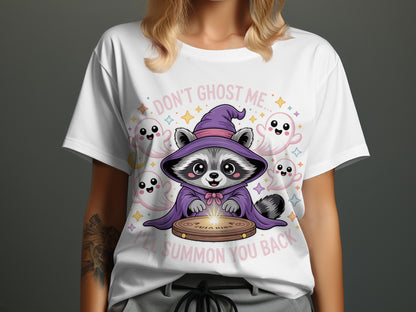 White t-shirt with cute raccoon in wizard outfit surrounded by ghosts and stars, text "DON'T GHOST ME... I'LL SUMMON YOU BACK".