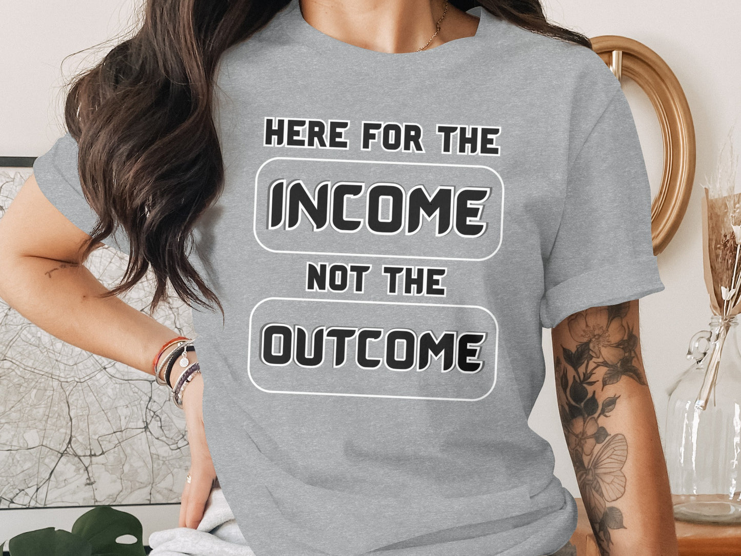 Grey t-shirt with text "HERE FOR THE INCOME NOT THE OUTCOME".