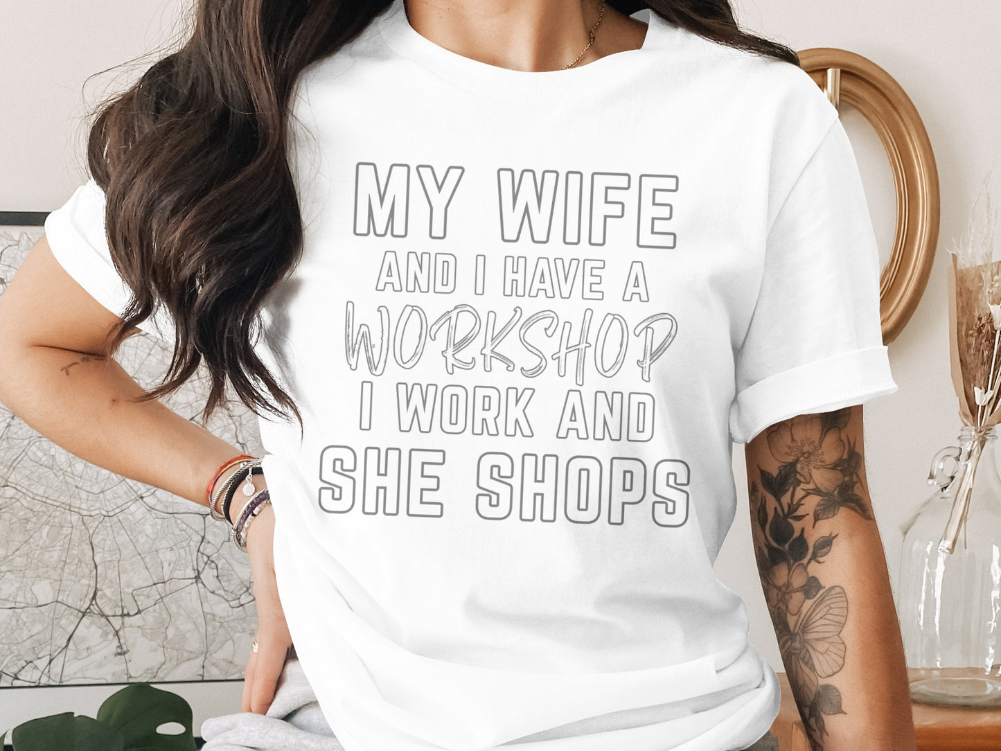 White t-shirt with text "MY WIFE AND I HAVE A WORKSHOP I WORK AND SHE SHOPS".