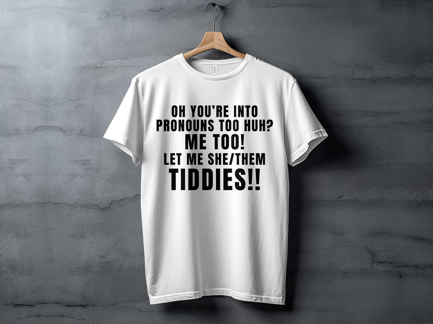White t-shirt with black text reading "Oh you're into pronouns too huh? Me too! Let me she/them tiddies!!"