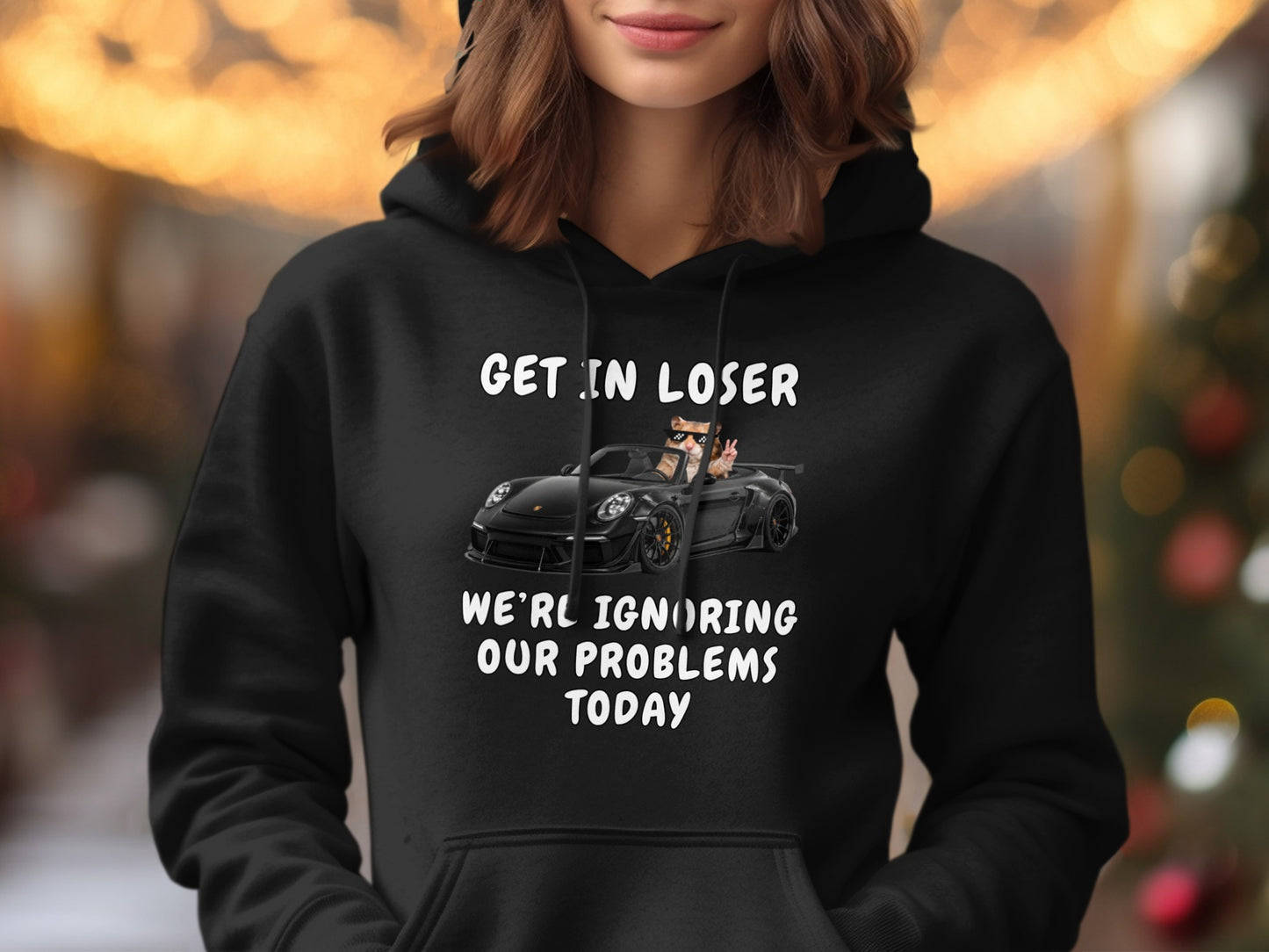 Black hoodie with cat driving a car and text "GET IN LOSER WE'RL IGNORING OUR PROBLEMS TODAY."