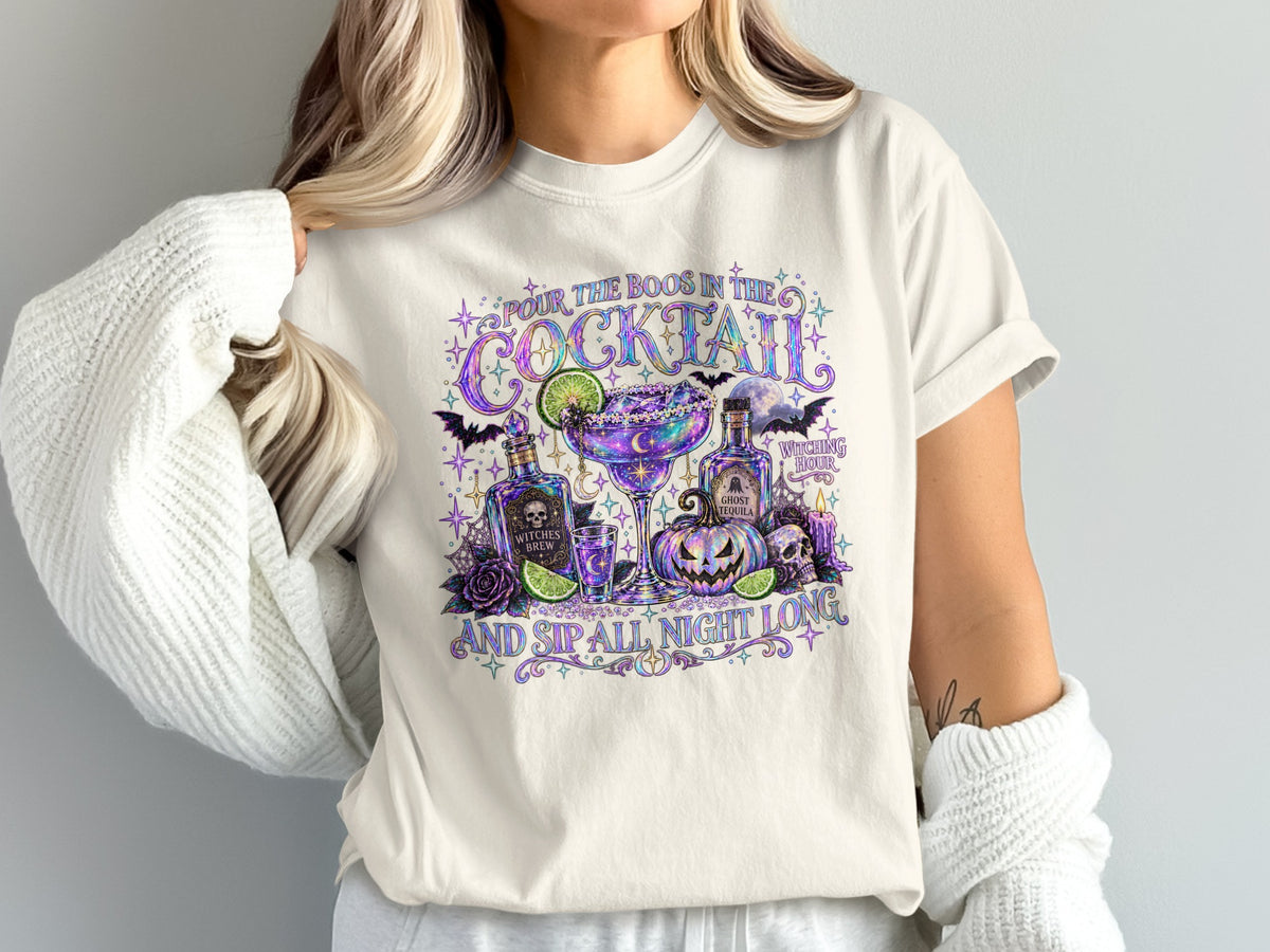 T-shirt graphic: "Pour the boos in the cocktail and sip all night long" with Halloween drink theme.
