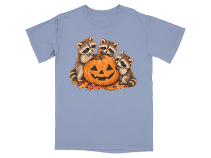 Three raccoons surround a carved jack-o'-lantern on fallen autumn leaves.