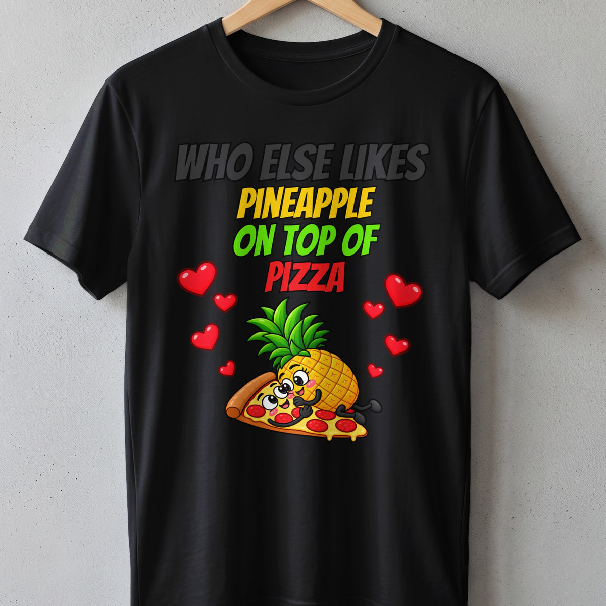 Black t-shirt with cartoon pineapple on pizza and hearts, text "Who else likes pineapple on top of pizza".