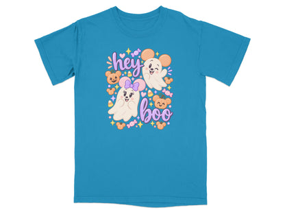 Cute ghost characters with mouse ears on a teal t-shirt with "hey boo" text.