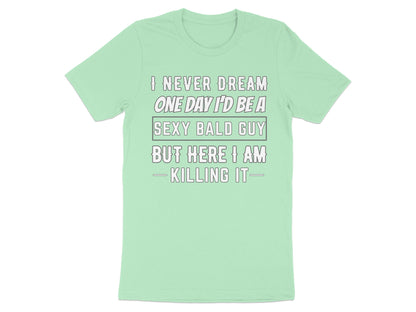 Light green t-shirt with text "I NEVER DREAM ONE DAY I'D BE A SEXY BALD GUY BUT HERE I AM KILLING IT".