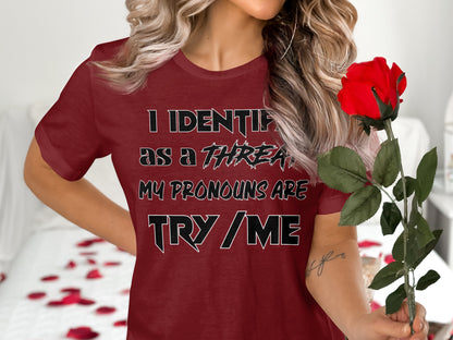 Burgundy t-shirt with "I identify as a threat. My pronouns are try/me." text and a red rose.