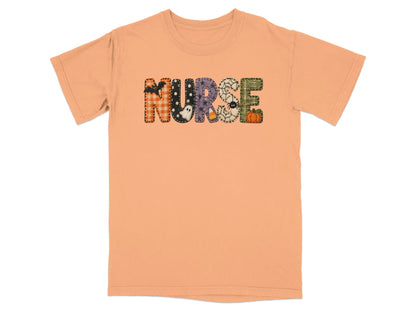Peach short-sleeve t-shirt with the word NURSE spelled out in patterned Halloween-themed block letters across the chest.