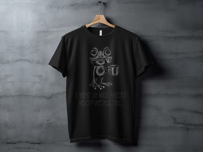 Black t-shirt with a cartoon frog holding a mug and text: "I HAVE TO SAY WEIRD STUFF OR I'LL DIE."