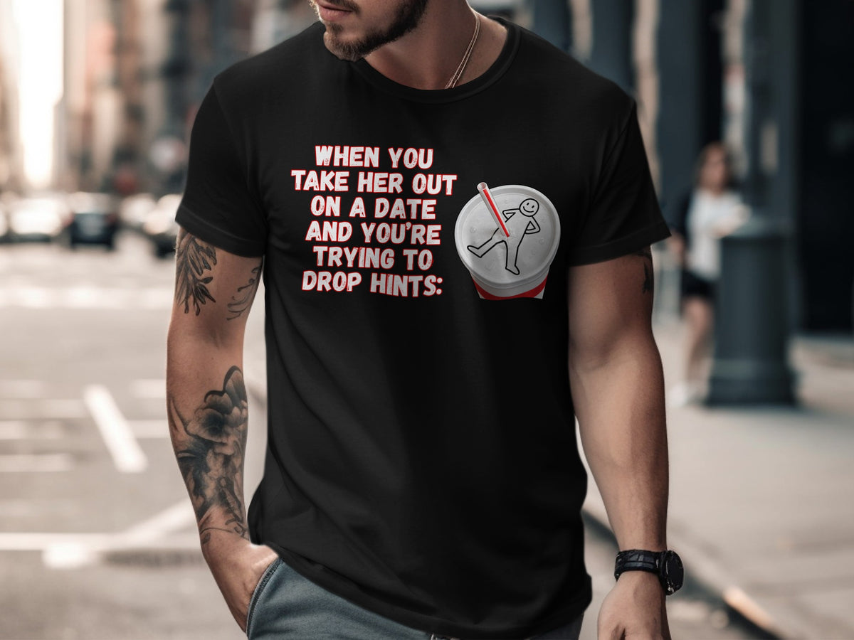 Black t-shirt with text "WHEN YOU TAKE HER OUT ON A DATE AND YOU'RE TRYING TO DROP HINTS:" and a drink.