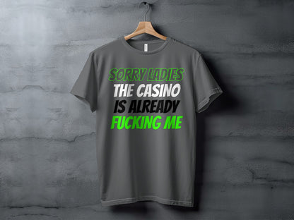 Grey t-shirt with text "SORRY LADIES THE CASINO IS ALREADY FUCKING ME".