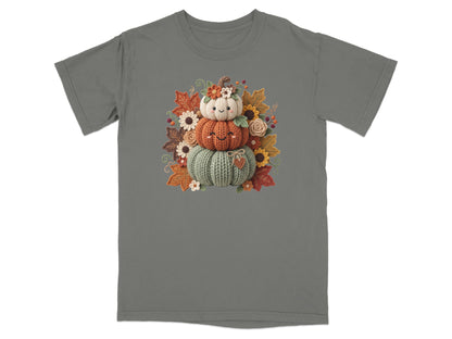 T-shirt with a stacked pumpkin design surrounded by autumn leaves and flowers.