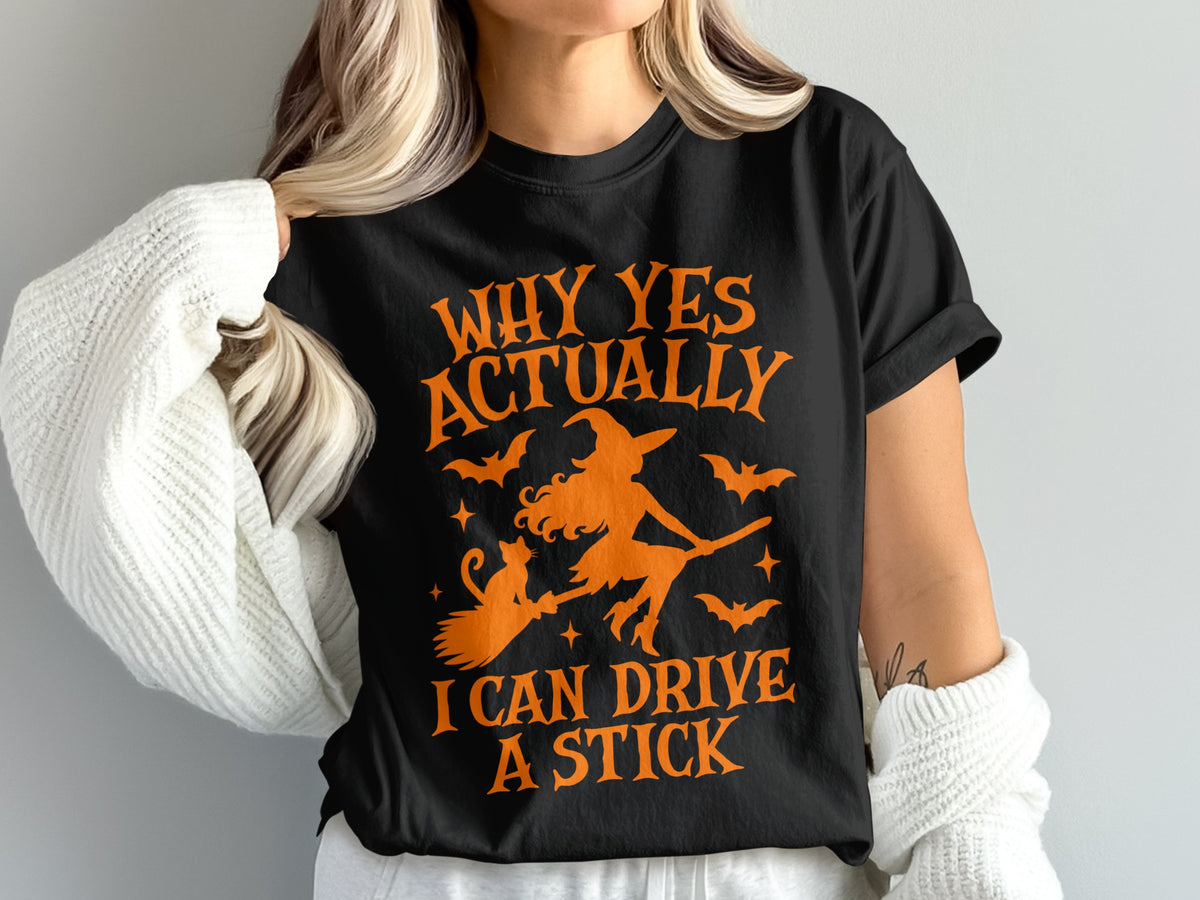 Black t-shirt with orange text and witch riding broom with cat.