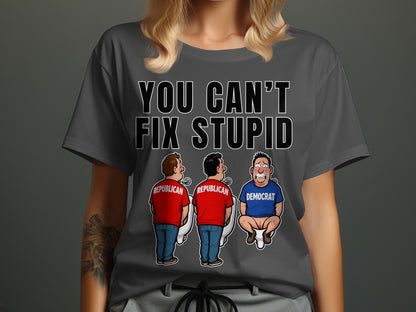 T-shirt with text "YOU CAN'T FIX STUPID" and cartoon of two Republicans at urinals and one crying Democrat on toilet.