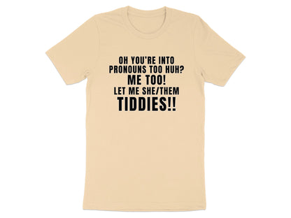 Light beige t-shirt with black text: "Oh you're into pronouns too huh? Me too! Let me she/them tiddies!!"