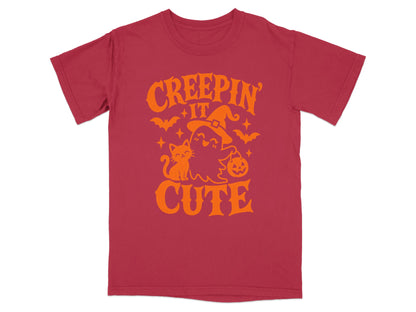 Red t-shirt with orange Halloween graphic "CREEPIN IT CUTE" featuring a ghost, cat, and pumpkin.