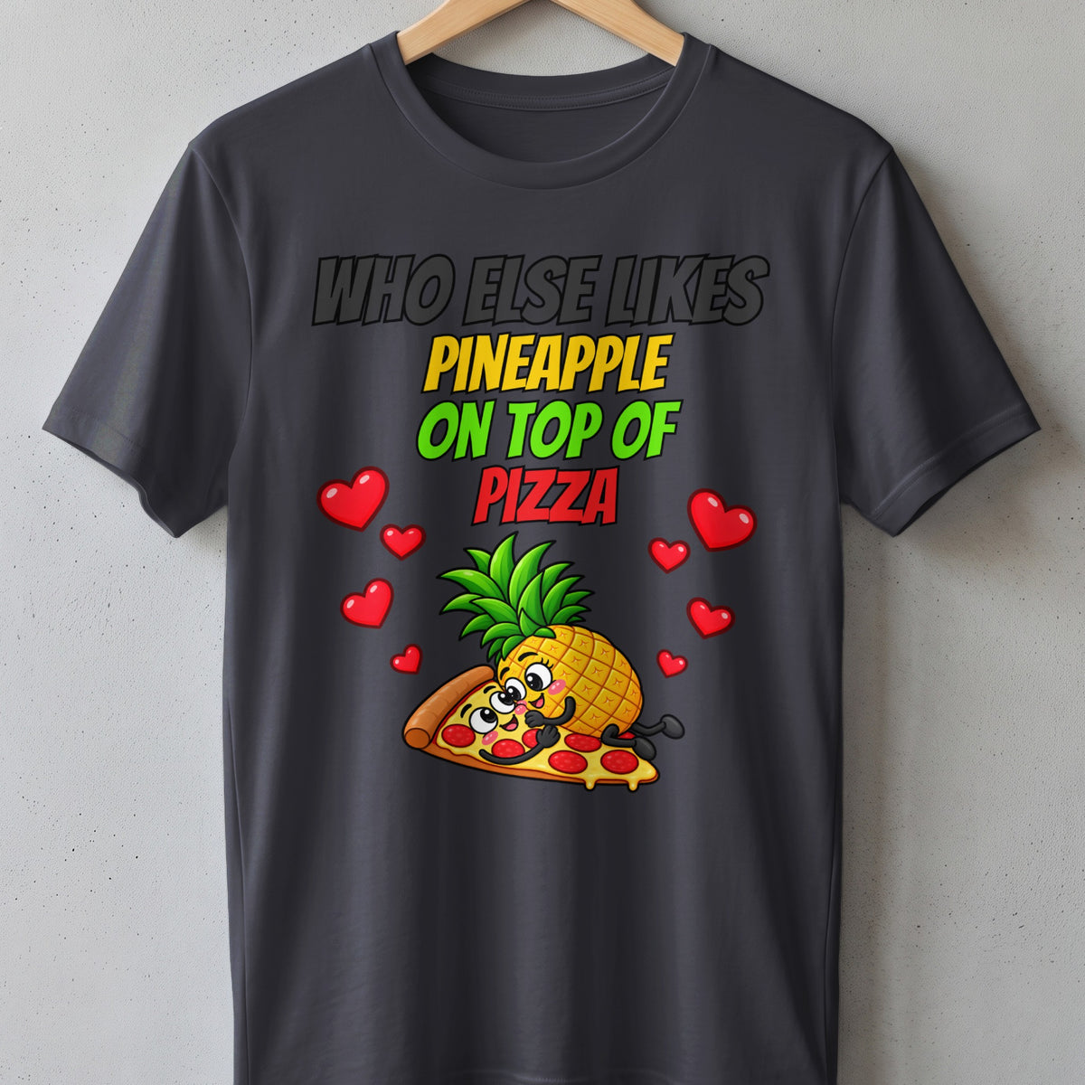 Dark grey t-shirt with text "Who Else Likes Pineapple On Top Of Pizza" and cartoon.