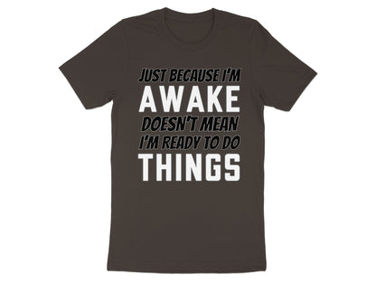 Dark grey t-shirt with white text "JUST BECAUSE I'M AWAKE DOESN'T MEAN I'M READY TO DO THINGS".