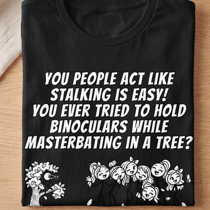 Black t-shirt with white text: "You people act like stalking is easy! You ever tried to hold binoculars while masterbating in a tree?"