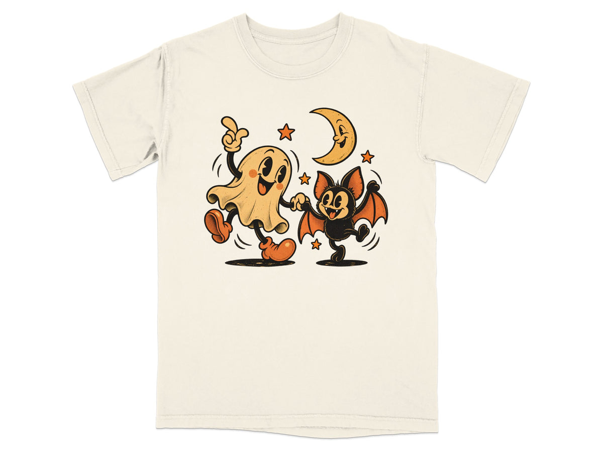 Ghost and bat dancing under a crescent moon and stars on a cream t-shirt.