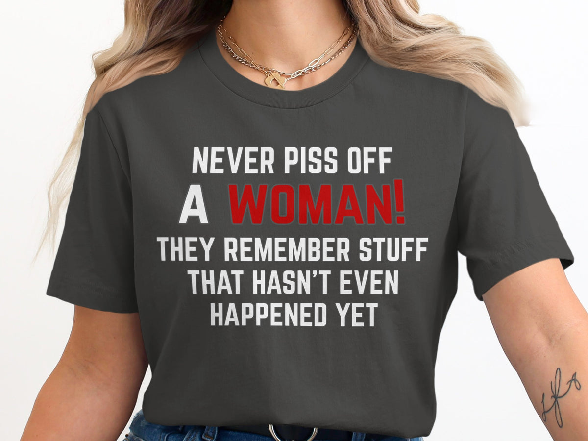 Dark grey t-shirt with white text "NEVER PISS OFF A WOMAN!" in red.