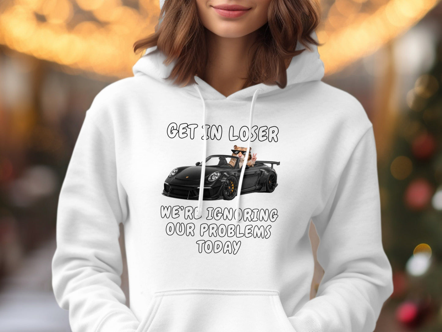 White hoodie with text "GET IN LOSER WE'RE IGNORING OUR PROBLEMS TODAY" and cartoon.