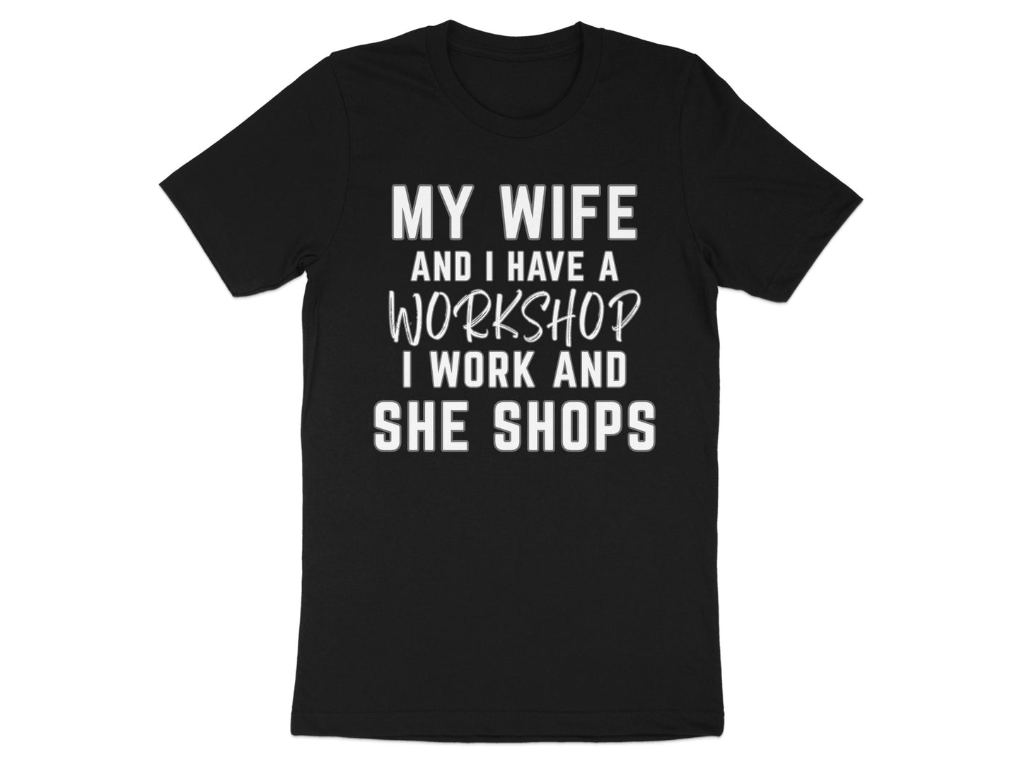 Black t-shirt with white text: "MY WIFE AND I HAVE A WORKSHOP I WORK AND SHE SHOPS"