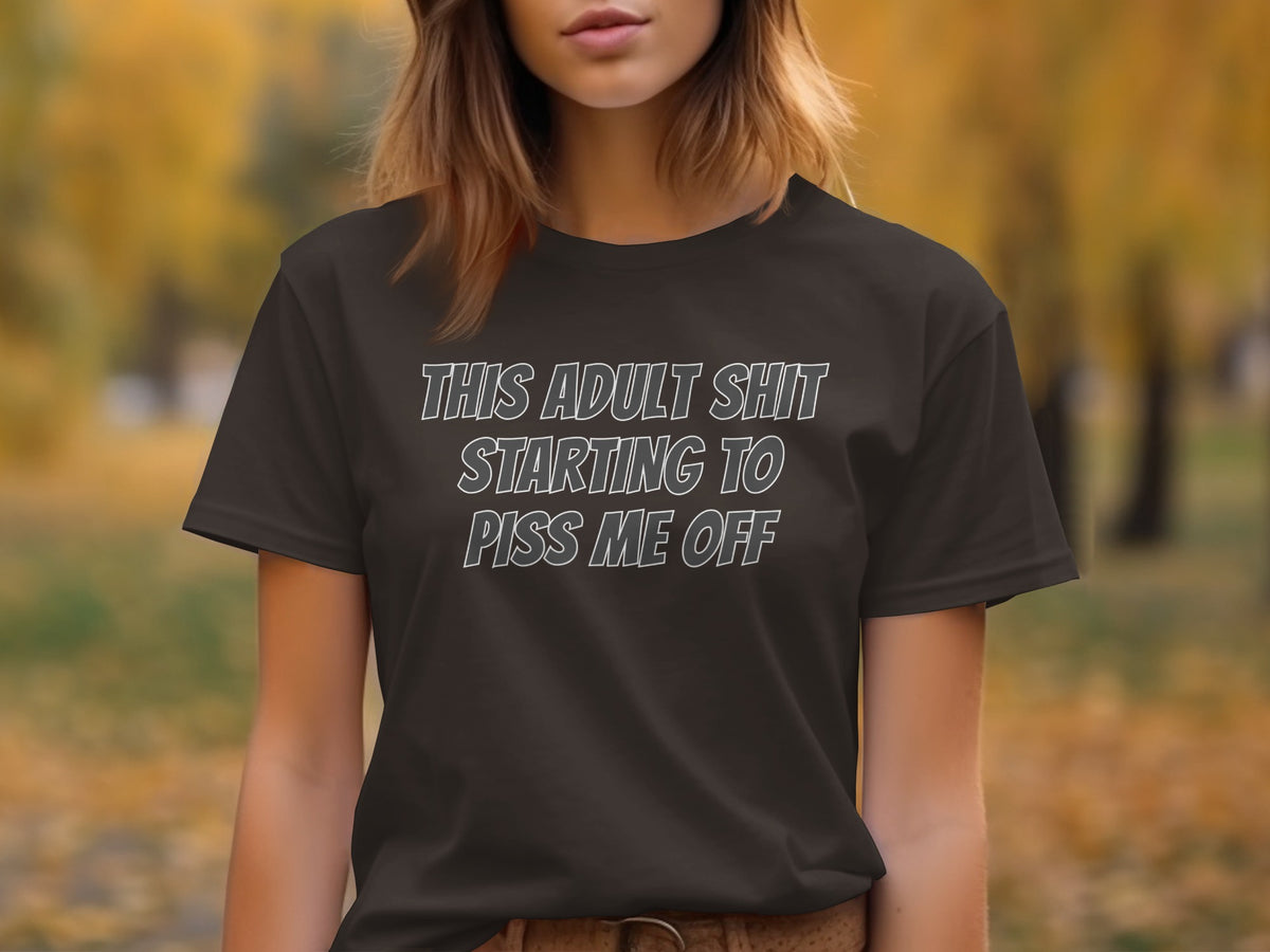 Dark t-shirt with text "THIS ADULT SHIT STARTING TO PISS ME OFF"
