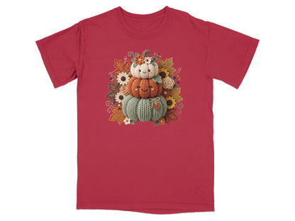 Stacked knitted pumpkins with a smiling face and autumn leaves.