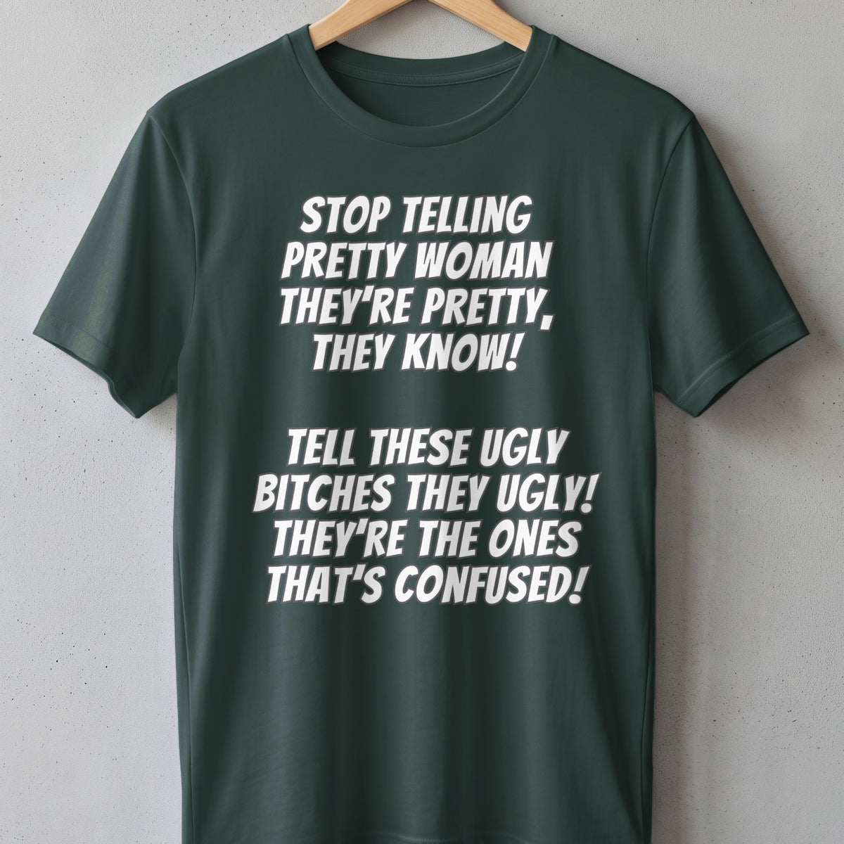 Dark green t-shirt with white text: "STOP TELLING PRETTY WOMAN THEY'RE PRETTY, THEY KNOW!"