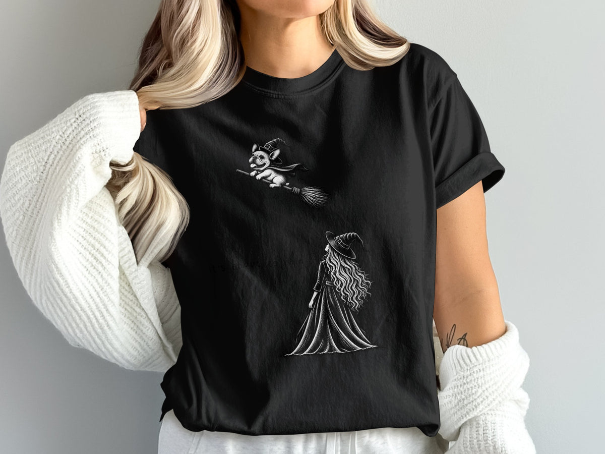 Black t-shirt with a drawing of a witch and a french bulldog flying on a broom.