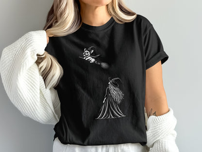 Black t-shirt with a drawing of a witch and a french bulldog flying on a broom.