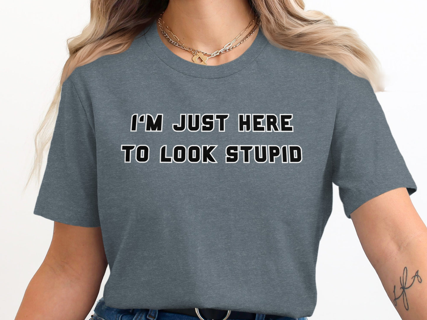 Dark gray t-shirt with black and white text "I'M JUST HERE TO LOOK STUPID".