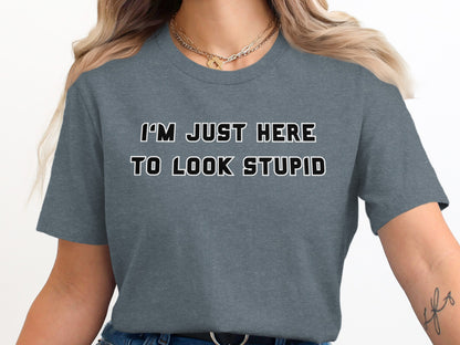 Dark gray t-shirt with black and white text "I'M JUST HERE TO LOOK STUPID".