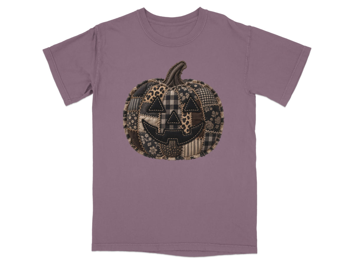 Patchwork jack-o'-lantern graphic on a mauve t-shirt.