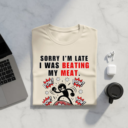 Cream t-shirt with "Sorry I'm Late I Was Beating My Meat" text and comic graphic.