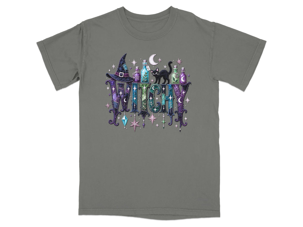 Grey t-shirt with "WITCHY" text, witch hat, black cat, potions, and stars.