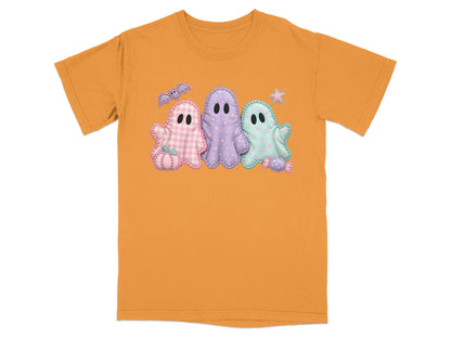 Orange t-shirt with a Halloween graphic featuring three pastel ghosts and a pumpkin.