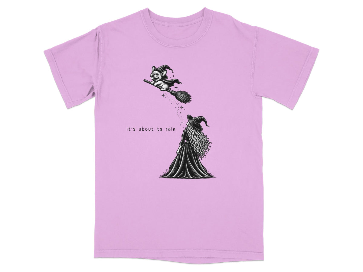 French bulldog in witch hat flying on broom over woman, text "It's about to rain."