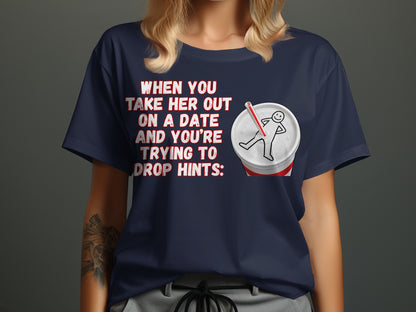 Dark blue t-shirt with text and soda cup graphic about dropping hints.