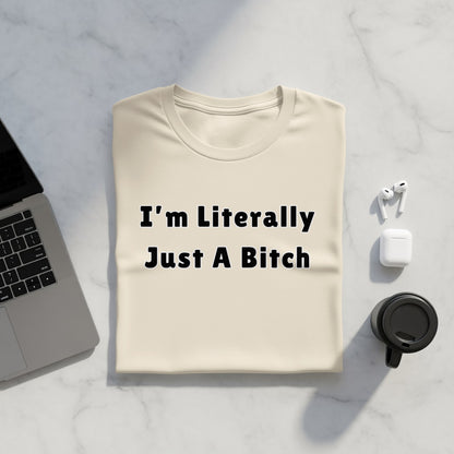 Cream t-shirt with black text "I'm Literally Just A Bitch," laptop, and earbuds.