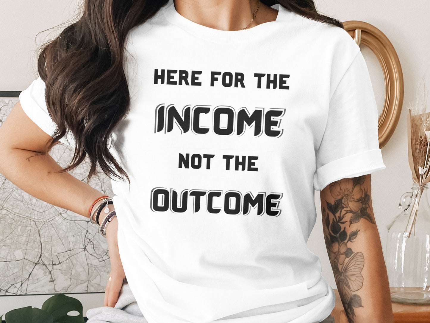 White t-shirt with black text: "HERE FOR THE INCOME NOT THE OUTCOME"