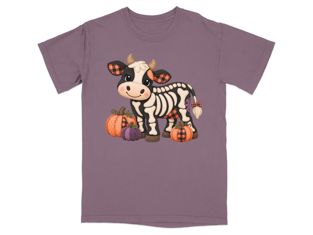 Cute skeleton cow with plaid accents stands with pumpkins.