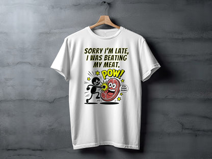 White t-shirt with cartoon text and graphic of man hitting meat.