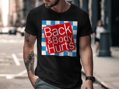 Black t-shirt with "Back & Body Hurts" text on a red and blue checkered design.